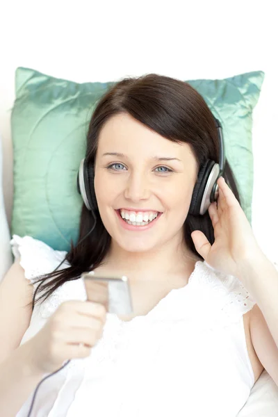 Mujer joven y feliz escuchando música con auriculares — Foto de Stock