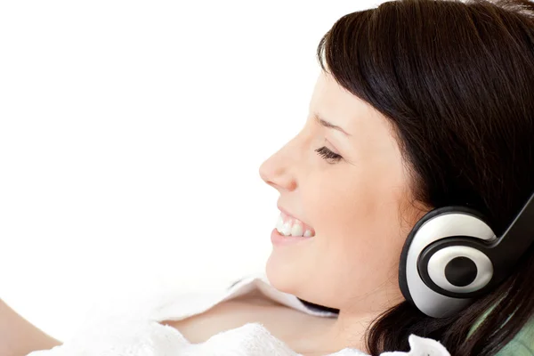 Freudige junge Frau, die mit Kopfhörern Musik hört — Stockfoto