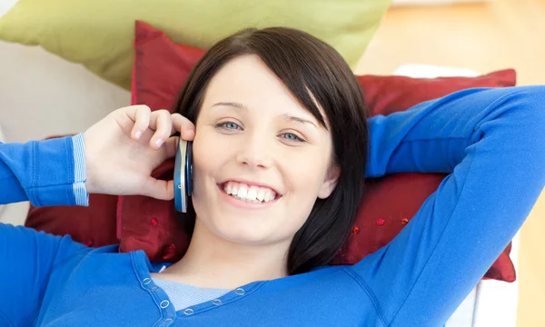 ソファーに横になっている携帯電話で話している魅力的な十代の少女 — ストック写真