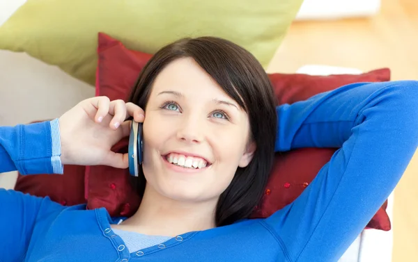 Hermosa chica adolescente hablando por teléfono tumbado en un sofá —  Fotos de Stock