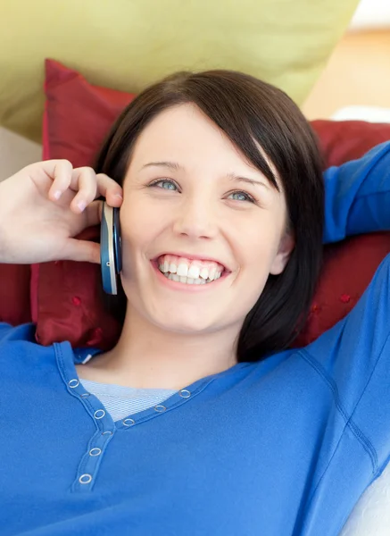 Szczęśliwa młoda kobieta rozmawia telefon leżąc na kanapie — Zdjęcie stockowe