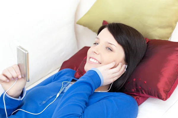 Glad kvinna lyssnar musik med hörlurar — Stockfoto