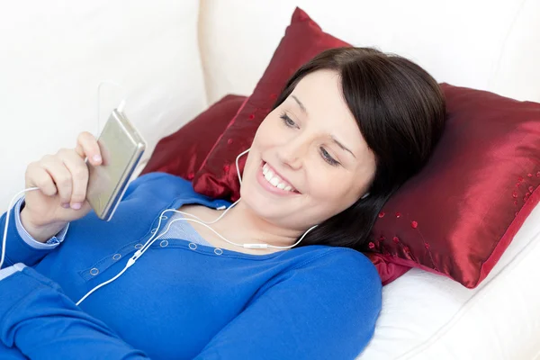 Donna sorridente che ascolta musica con le cuffie — Foto Stock