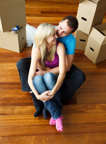 Feliz casal jovem sentado no chão. Mudança de casa — Fotografia de Stock