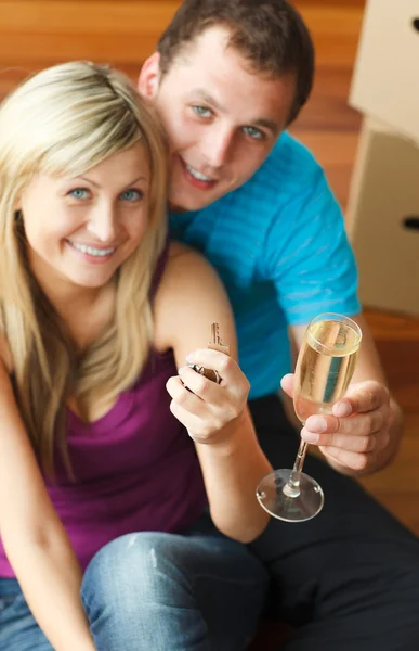 Счастливая пара празднует новый дом с шампанским — стоковое фото