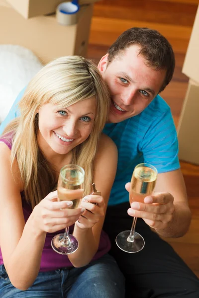 Ângulo alto de um casal feliz celebrando nova casa com champanhe — Fotografia de Stock