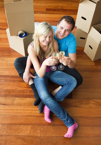 Amantes felizes movendo casa e bebendo champanhe — Fotografia de Stock