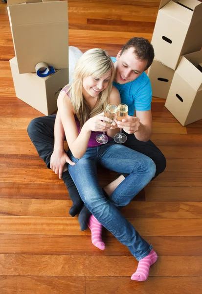 新しいアパートのシャンパンを祝う幸せなカップル — ストック写真