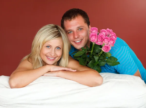 Casal no sofá segurando um buquê de rosa — Fotografia de Stock