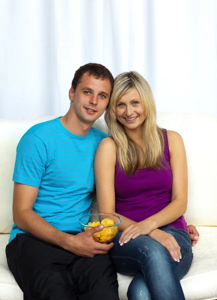 Couple watching television and eating crisps — Stock Photo, Image