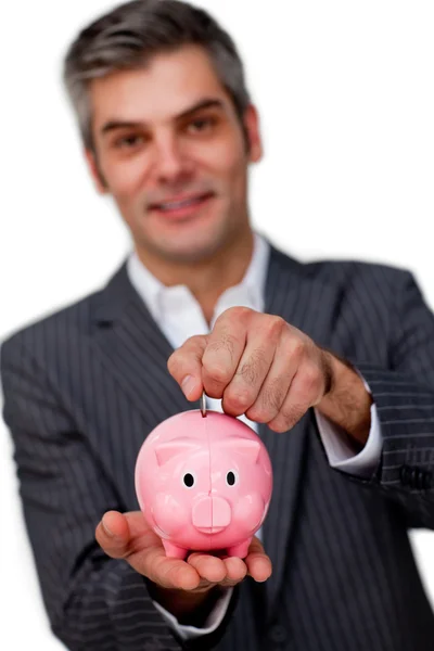 Carismático executivo do sexo masculino economizando dinheiro em um mealheiro — Fotografia de Stock