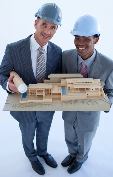 Engineers with hard hats holding a model house — Stock Photo, Image