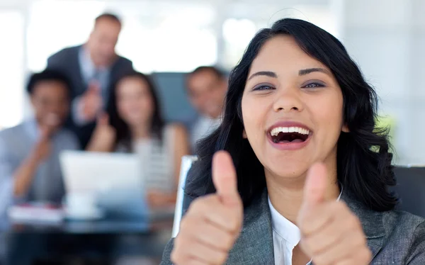 Счастливая деловая женщина с большими пальцами в офисе — стоковое фото