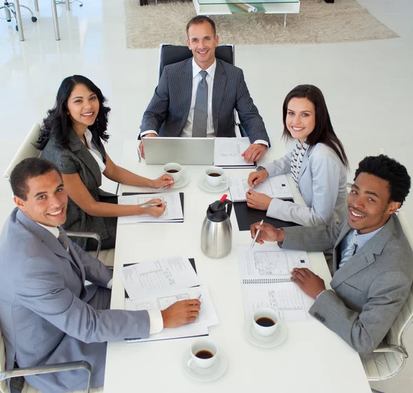 Business in een vergadering glimlachen naar de camera — Stockfoto