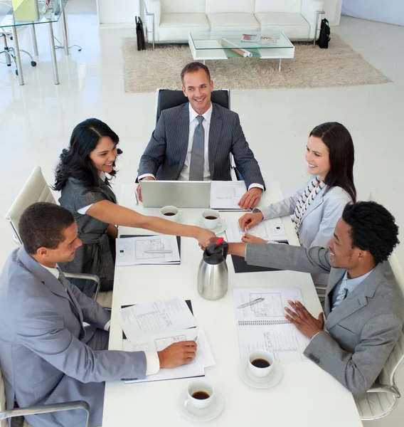 Empresária e empresário apertando as mãos em uma reunião — Fotografia de Stock