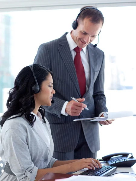 Manager talking to an ethnic businesswoman in a call center — Stock Photo, Image