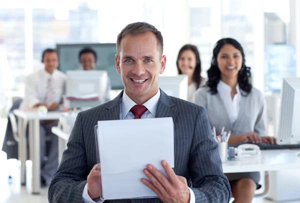 Smiling manager writing notes in a call center — Stock Photo, Image