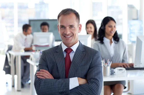 Manager sorridente che guida il suo team in un call center — Foto Stock
