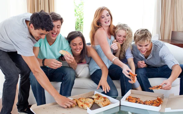 在家里吃披萨的朋友 免版税图库照片
