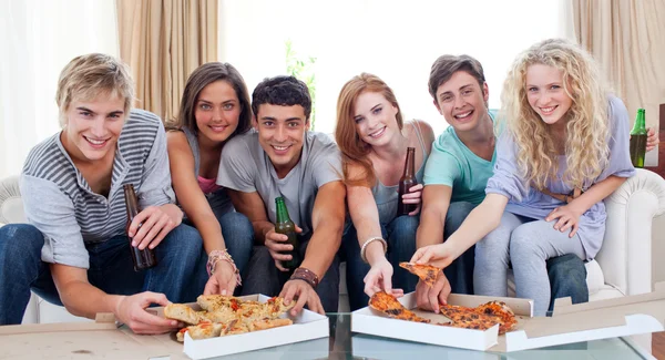 在家里吃披萨的朋友 免版税图库图片