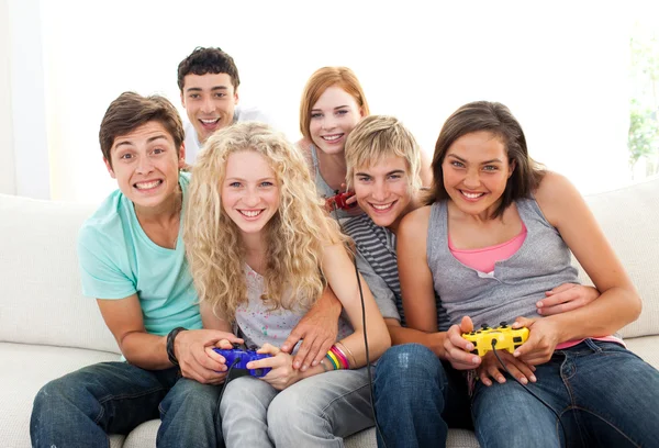 Друзья играют в видеоигры в гостиной — стоковое фото