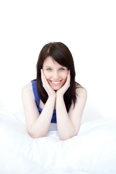 Portrait of a smiling woman sitting on her bed Stock Image