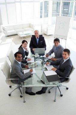 High angle of a business team smiling at the camera clipart