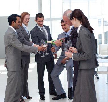 Successful businessman serving Champagne to his colleagues clipart