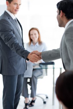Businessmen greeting each other at a job interview clipart