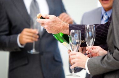 Close-up of a business man opening a bottle of Champagne clipart