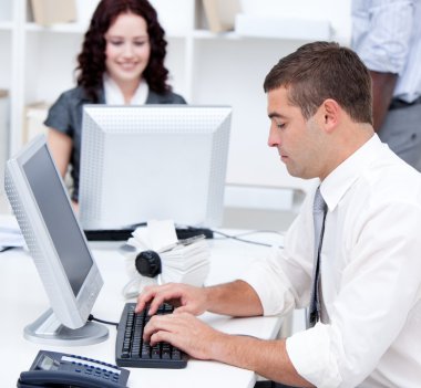 Assertive young business working at computers clipart