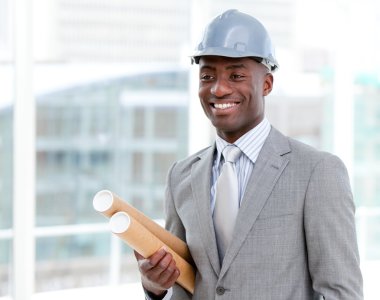 Portrait of a cheerful male architect holding blueprints clipart