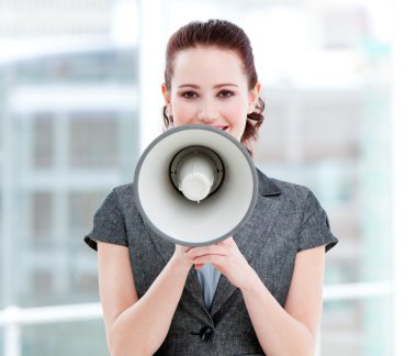 Confident businesswoman yelling through a megaphone clipart