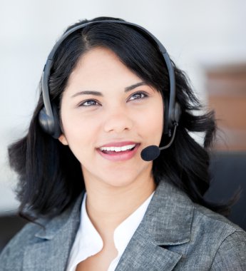 Smiling businesswoman wearing a headset to talk with customer clipart