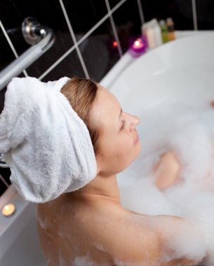 Caucasian woman taking in a bubble bath clipart