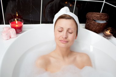 Beautiful woman relaxing in a bubble bath clipart