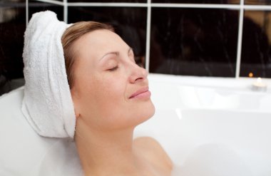 Bright woman relaxing in a bubble bath clipart