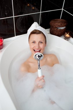 Happy woman singing in a bubble bath clipart