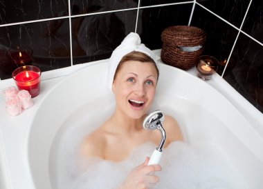 Cheerful young woman singing in a bubble bath clipart