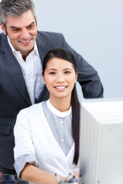 Asian businesswoman and her manager working at a computer clipart