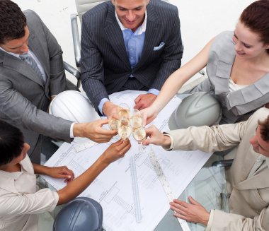 Close-up of enginners toasting with champagne in the office clipart