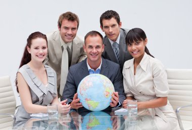 Business team holding a terrestrial globe. Global business clipart