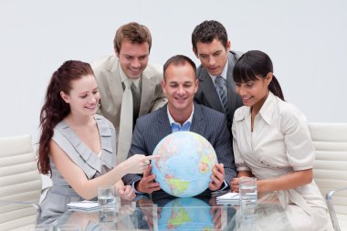 Business team holding a terrestrial globe. International busines clipart