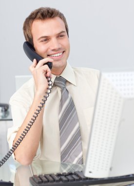 Businessman talking on phone in the office and working with a co clipart