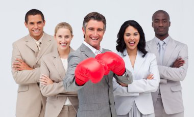 Smiling businessman with boxing gloves leading his team clipart