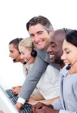 Mature manager and his team working in a call center clipart