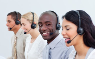 Ethnic man and his team working in a call center clipart