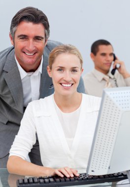 Confident business team working at a computer clipart