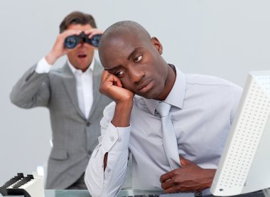 Afro-american businessman annoyed by a man looking through binoc clipart