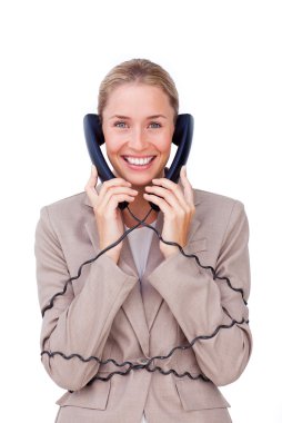 Smiling businesswoman tangled up in phone wires clipart